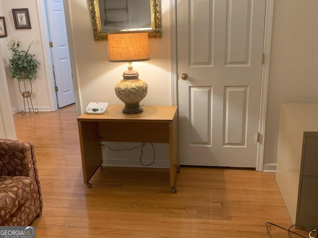 hallway with light wood-type flooring and baseboards