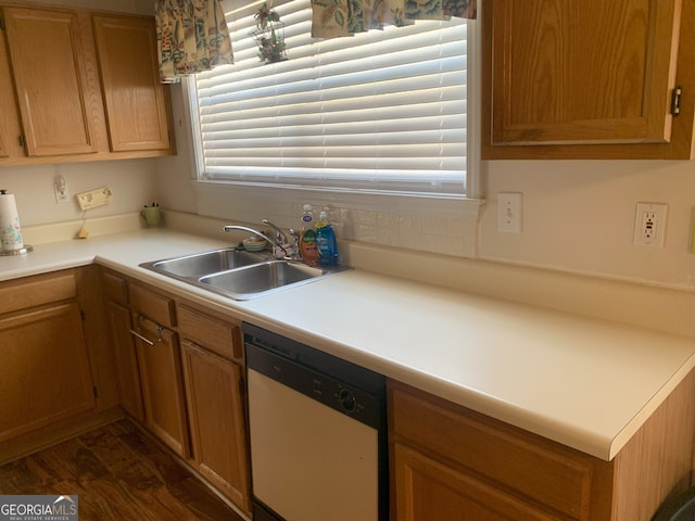 kitchen with dark wood-type flooring, light countertops, dishwasher, and a sink