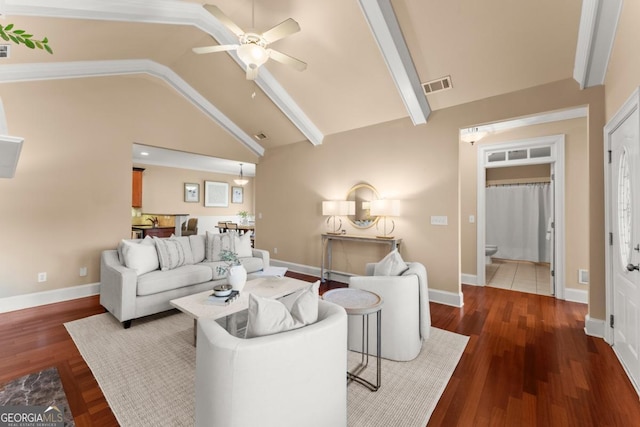 living area with vaulted ceiling, wood finished floors, visible vents, and baseboards