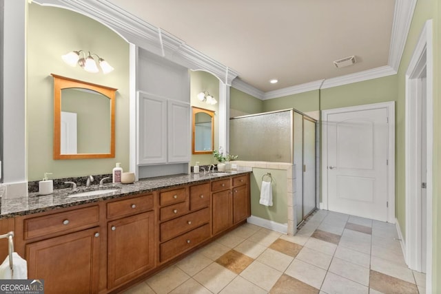 full bathroom with double vanity, ornamental molding, a stall shower, and a sink