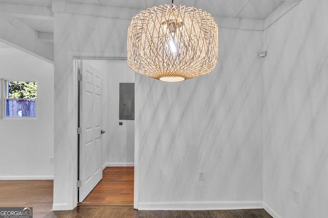 interior space with baseboards, electric panel, a chandelier, and wood finished floors