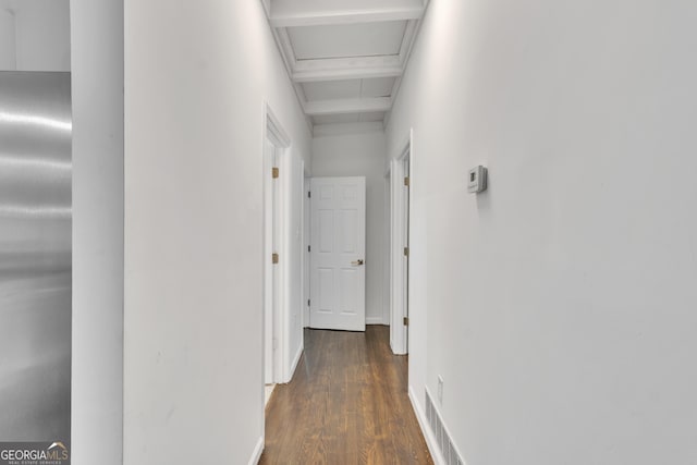 hall featuring beam ceiling, dark wood-style flooring, visible vents, and baseboards