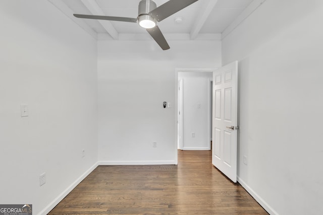 empty room featuring ceiling fan, beamed ceiling, wood finished floors, and baseboards