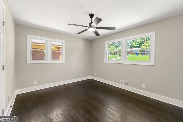 unfurnished room featuring baseboards, visible vents, and dark wood-type flooring