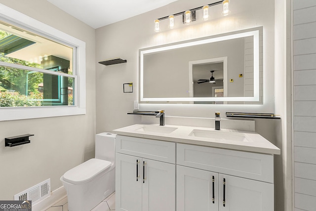 bathroom with visible vents, a sink, toilet, and double vanity