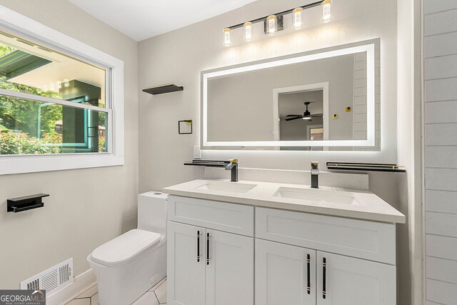 2682 Miriam Ln, Decatur, GA 30032 - bathroom with double vanity, toilet, ceiling fan, and baseboards