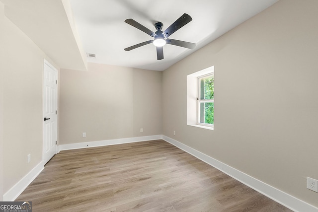 empty room featuring baseboards, visible vents, and light wood-style floors