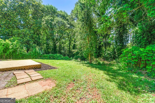 view of yard featuring a deck and a forest view