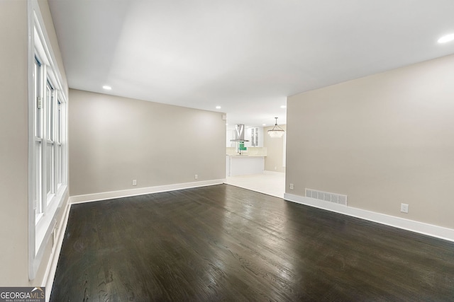 interior space featuring recessed lighting, visible vents, dark wood finished floors, and baseboards