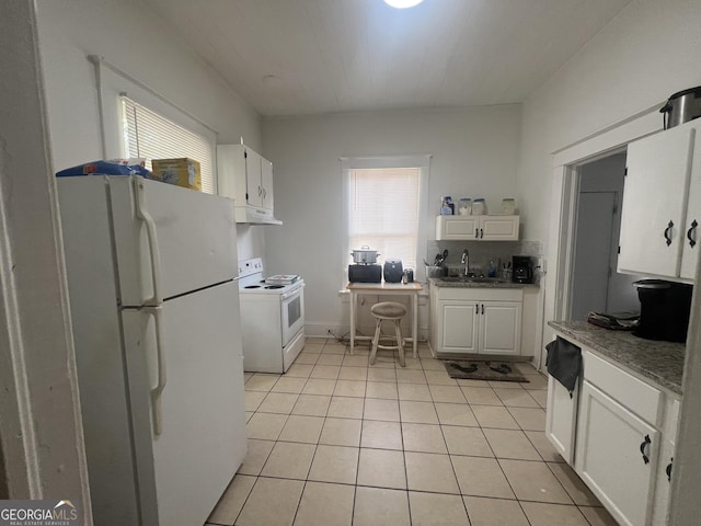 kitchen featuring white appliances, white cabinetry, a wealth of natural light, and a sink