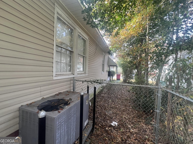 view of side of property featuring fence and cooling unit