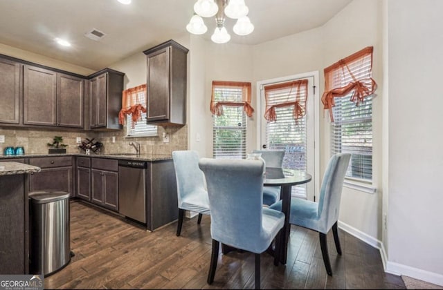 dining space with dark wood-style floors, baseboards, visible vents, and a chandelier