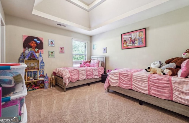 carpeted bedroom featuring a raised ceiling and visible vents