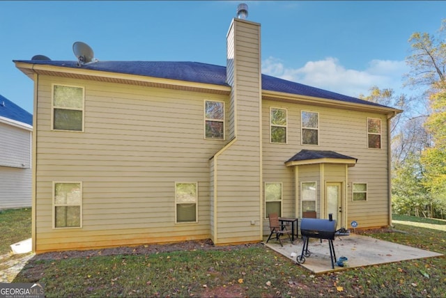 rear view of property with a chimney and a patio