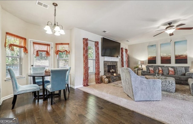 living room with visible vents, dark wood-type flooring, and a stone fireplace