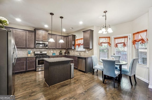 kitchen with decorative backsplash, appliances with stainless steel finishes, dark wood-type flooring, a sink, and dark brown cabinets