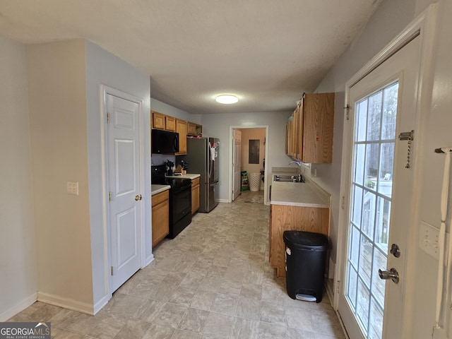220 Joe Dr, Temple, GA 30179 - kitchen with light countertops, a sink, brown cabinets, baseboards, and black appliances