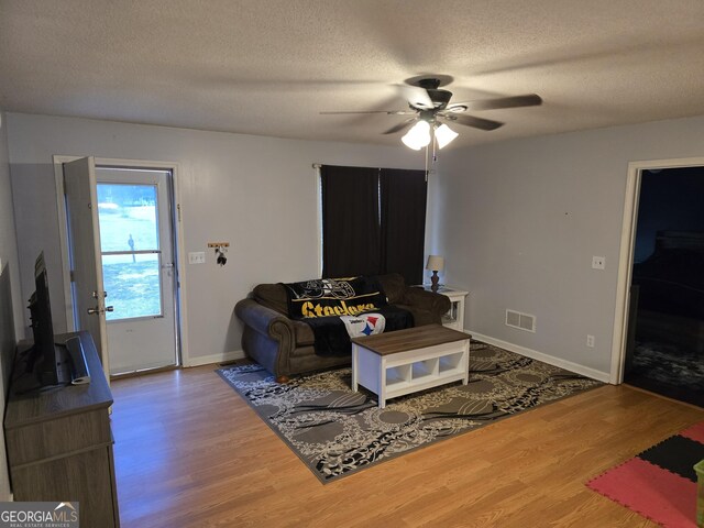 220 Joe Dr, Temple, GA 30179 - living area featuring a ceiling fan, a textured ceiling, baseboards, and wood finished floors