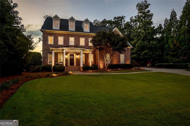 view of front facade featuring brick siding and a front lawn