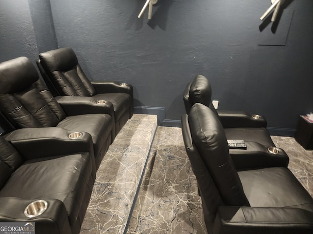 home theater room featuring baseboards and a textured wall