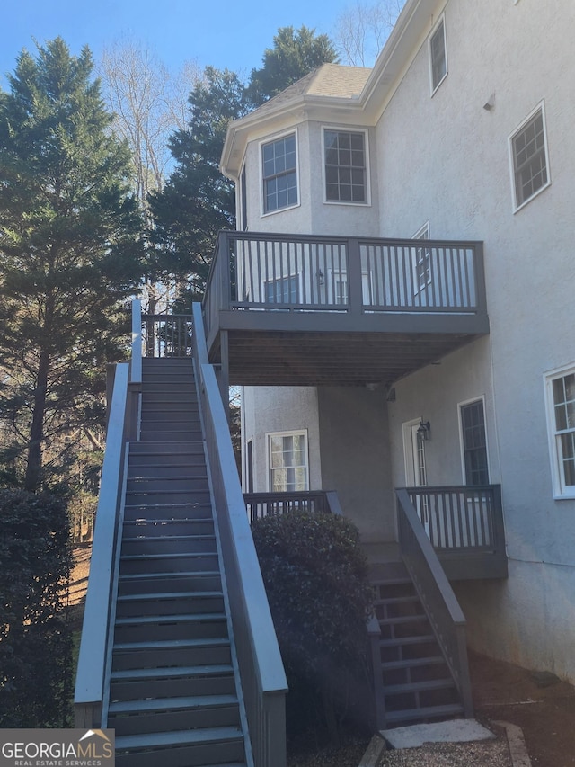 exterior space featuring stucco siding and stairs