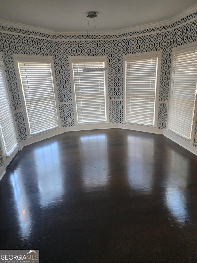 unfurnished room with crown molding, dark wood-type flooring, and wallpapered walls