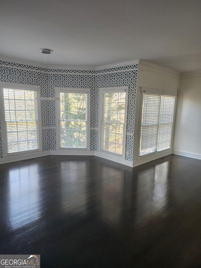 unfurnished room with a wealth of natural light, crown molding, and wallpapered walls