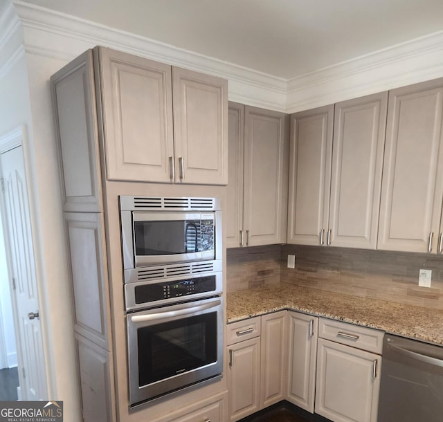 kitchen with appliances with stainless steel finishes, light stone counters, and backsplash