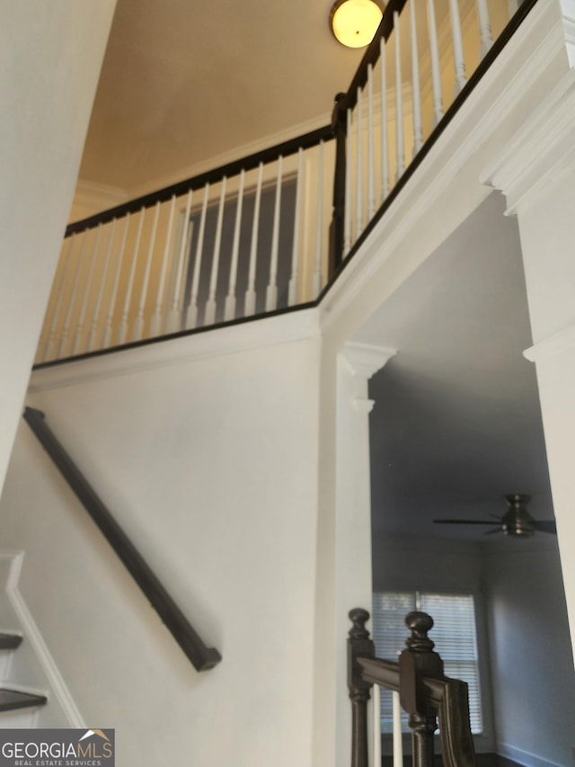 stairway featuring a ceiling fan