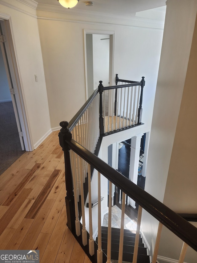 staircase with baseboards, ornamental molding, and hardwood / wood-style floors