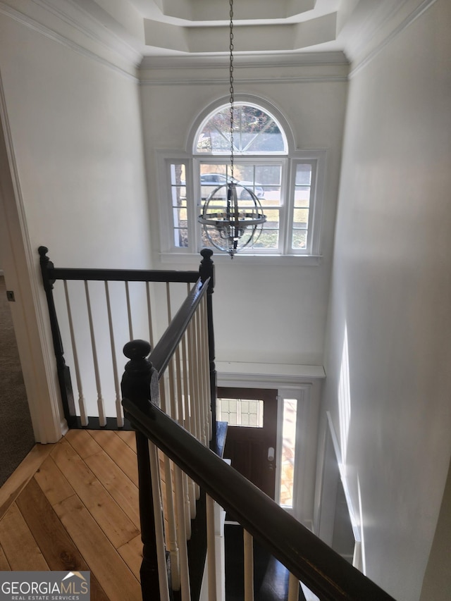 staircase with a chandelier and hardwood / wood-style flooring