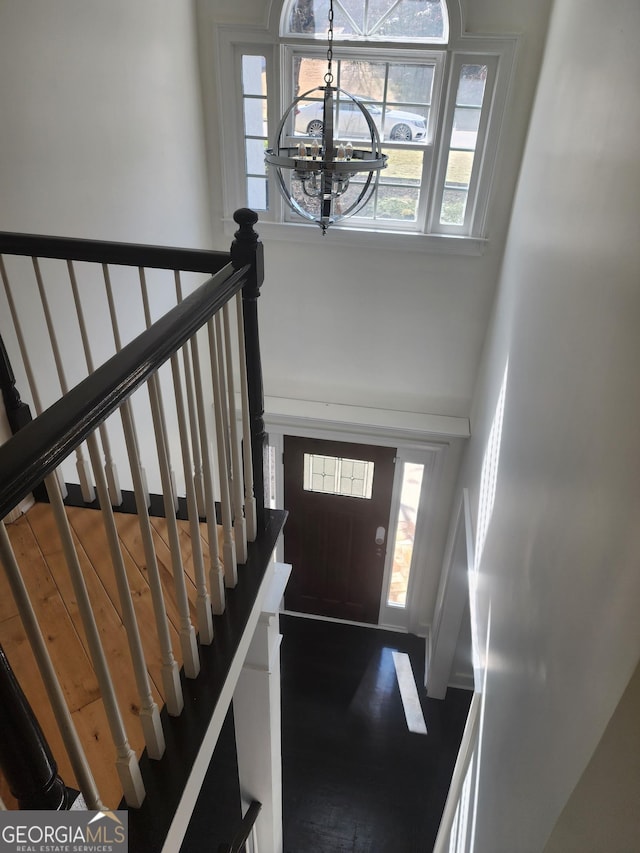 entryway with a towering ceiling and a notable chandelier