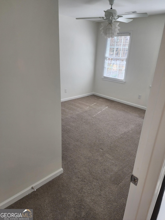 unfurnished room featuring carpet floors, ceiling fan, and baseboards