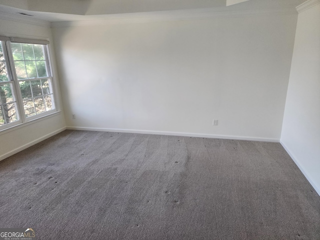 carpeted spare room featuring baseboards and ornamental molding