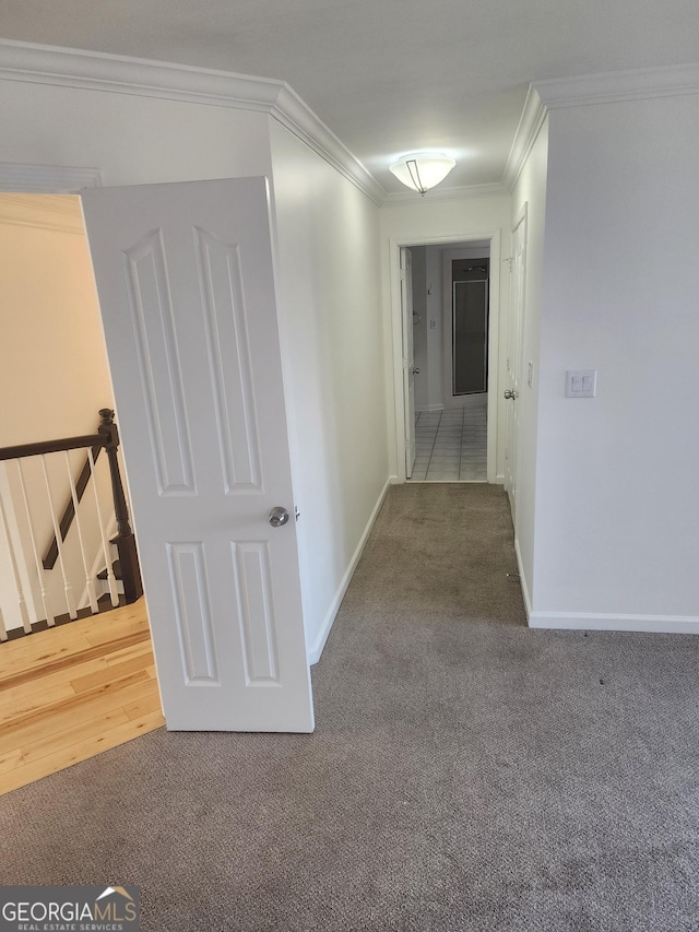 corridor with ornamental molding, carpet, an upstairs landing, and baseboards