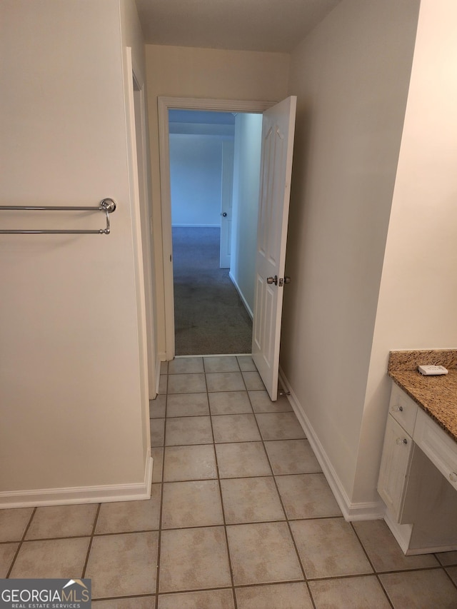 bathroom with vanity, baseboards, and tile patterned floors