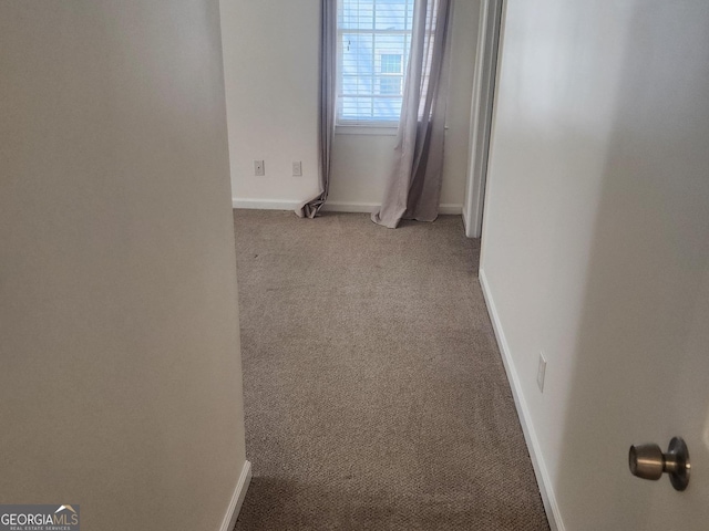 empty room featuring light carpet and baseboards