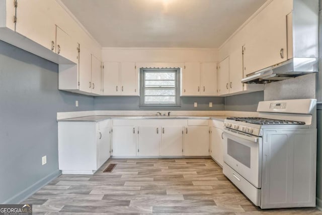 kitchen with light countertops, ornamental molding, and white range with gas cooktop