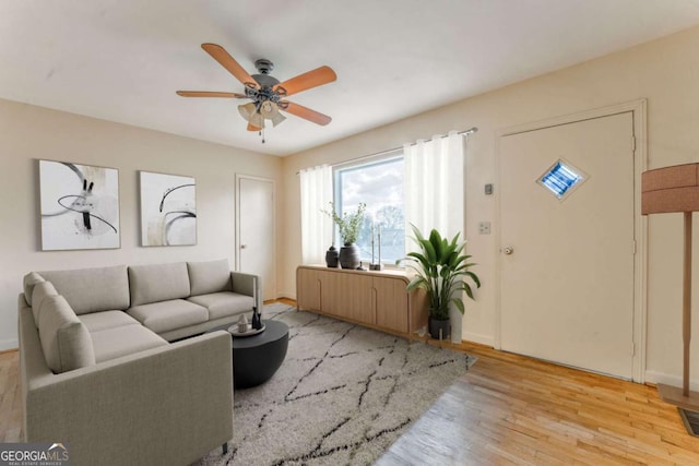 living area featuring visible vents, ceiling fan, light wood-style flooring, and baseboards