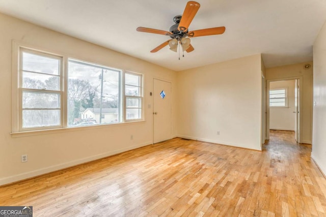 empty room with light wood-style floors, ceiling fan, and baseboards