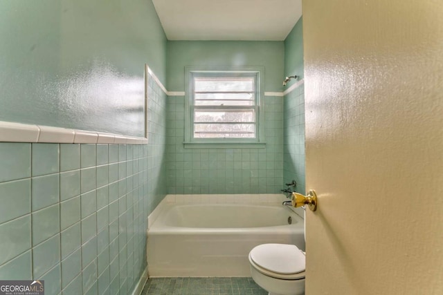 full bathroom with a tub to relax in, toilet, tile patterned flooring, walk in shower, and tile walls