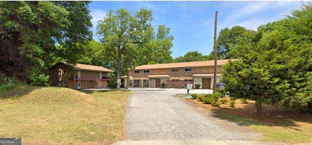 view of front of house featuring driveway and a front lawn