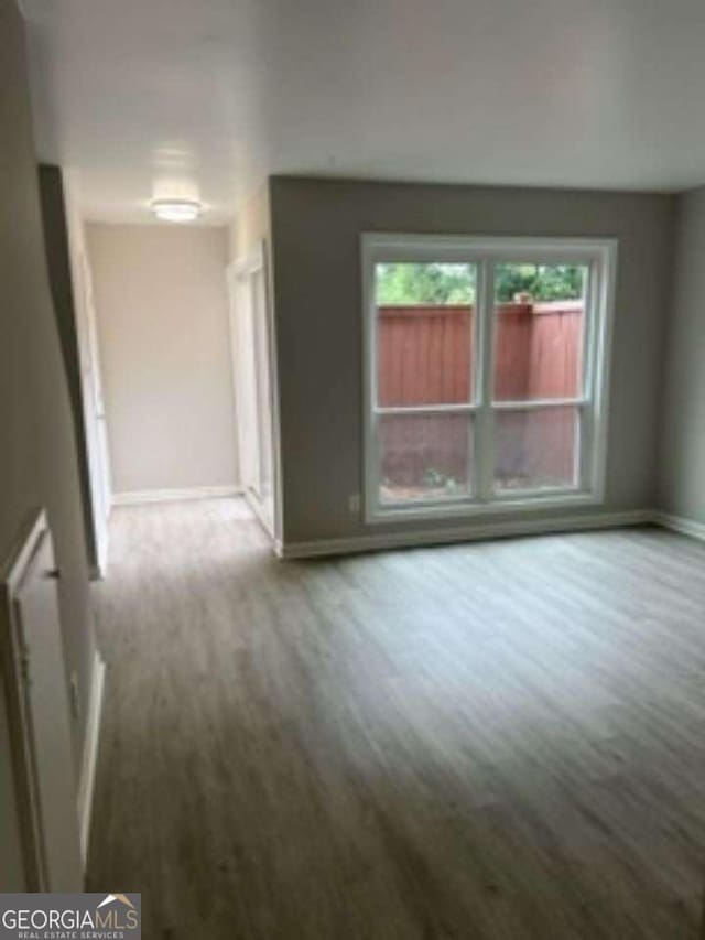 empty room featuring wood finished floors and baseboards