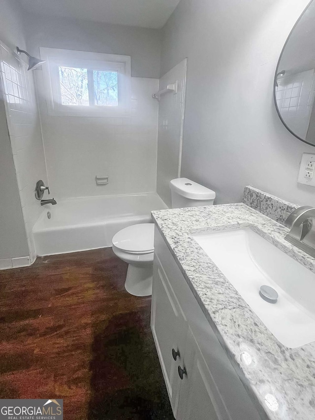 full bath featuring shower / bathtub combination, vanity, wood finished floors, and toilet