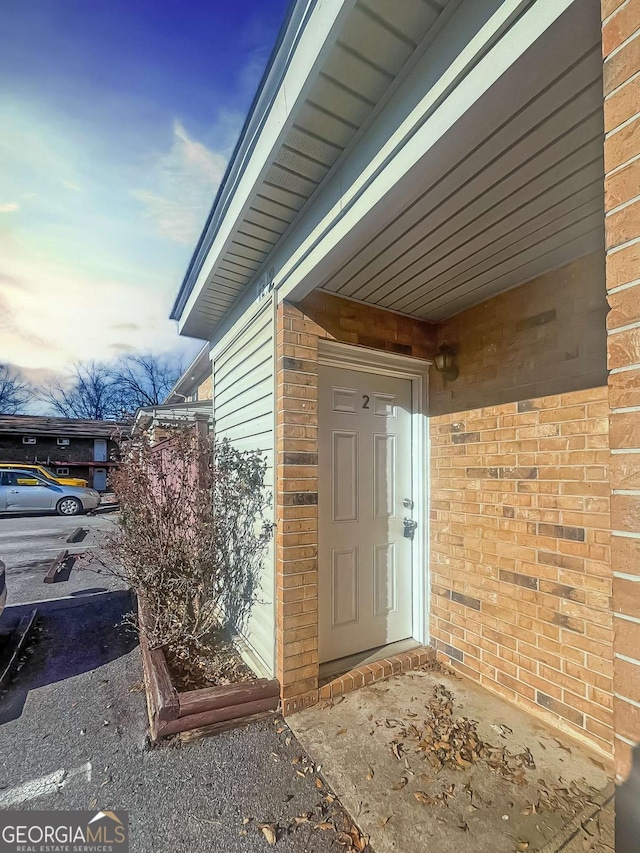 entrance to property featuring brick siding