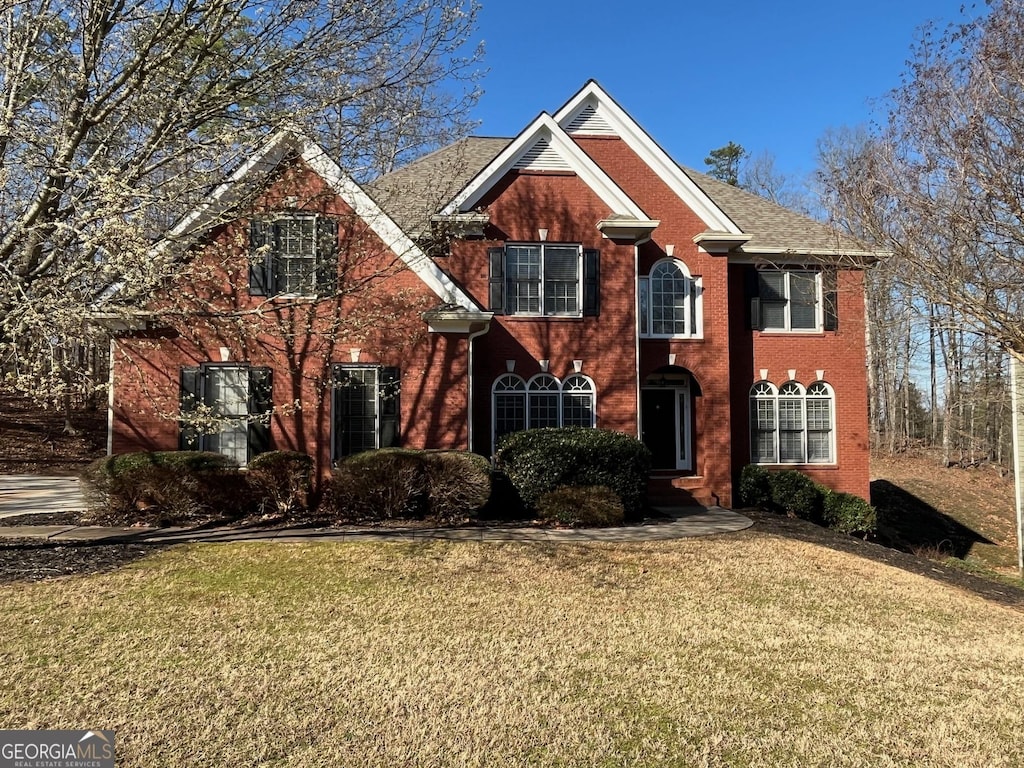 view of front of property with brick siding and a front yard