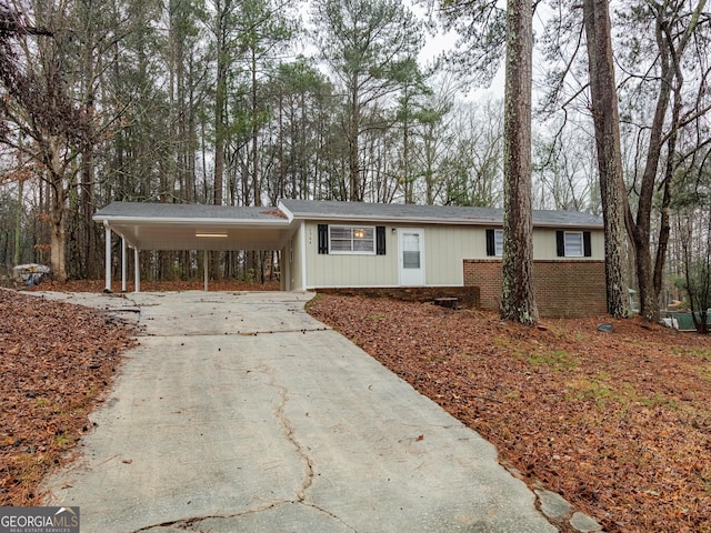 ranch-style house with an attached carport, concrete driveway, and brick siding