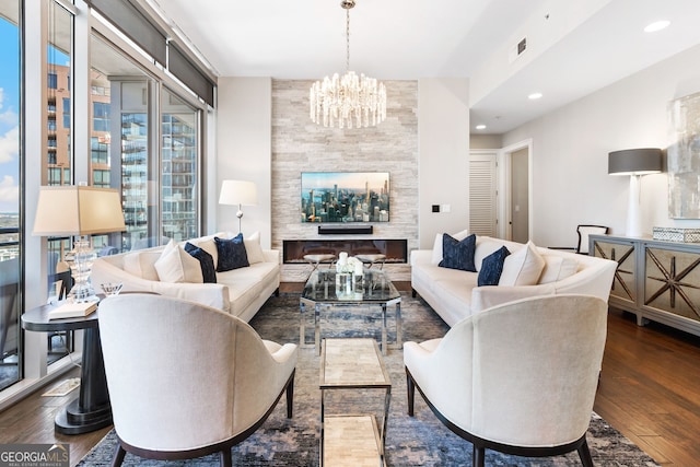 living area featuring visible vents, wood finished floors, recessed lighting, an inviting chandelier, and a fireplace