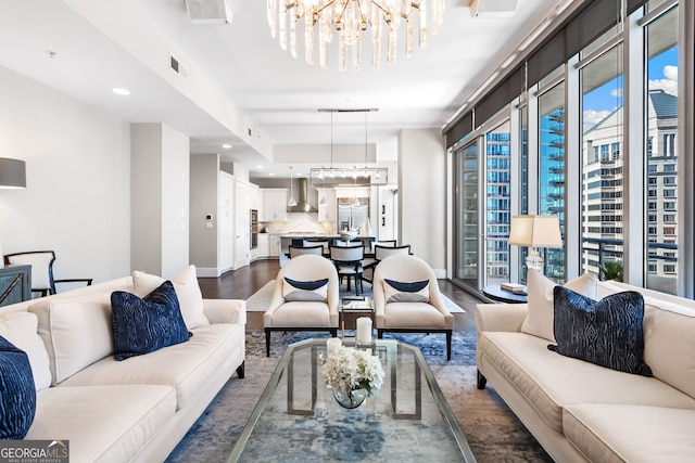 living room with dark wood-style floors, visible vents, plenty of natural light, and a chandelier