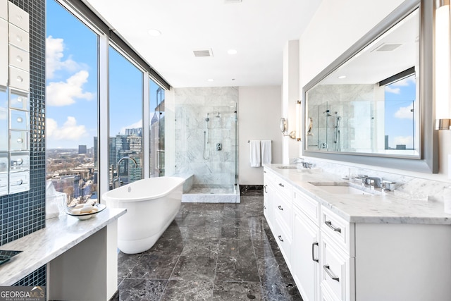 full bathroom featuring double vanity, a view of city, a stall shower, and a sink